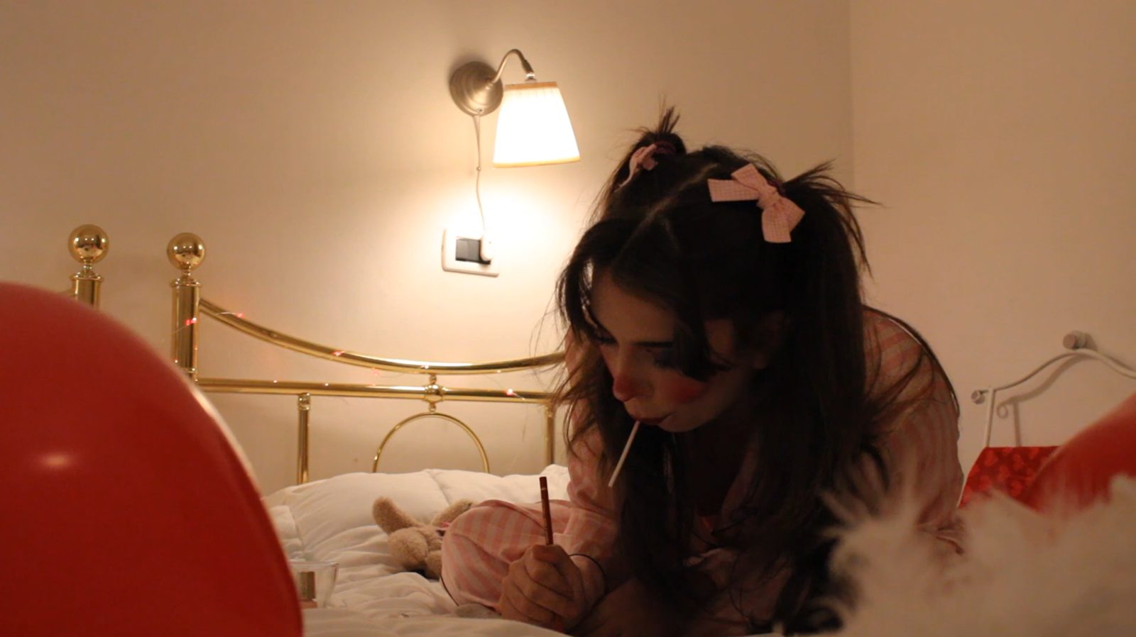 Lovesick — writing on the bed under a wall lamp