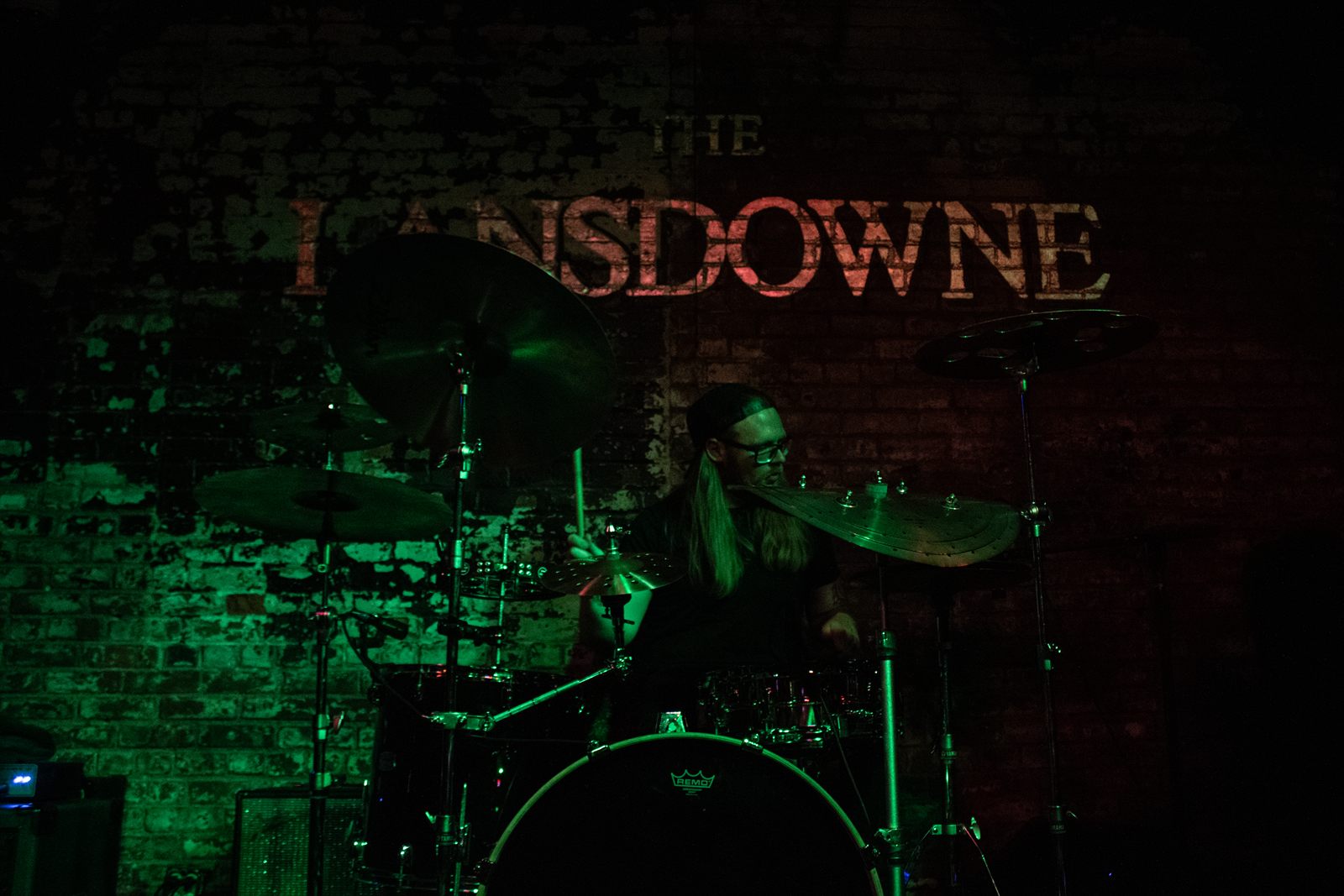 Tenderheds — the drummer in green light under the venue sign
