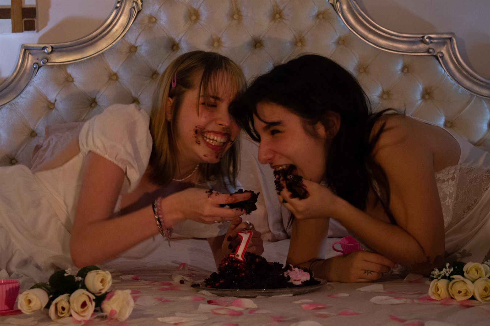 Directed — two girls eating cake on a bed, lit and styled