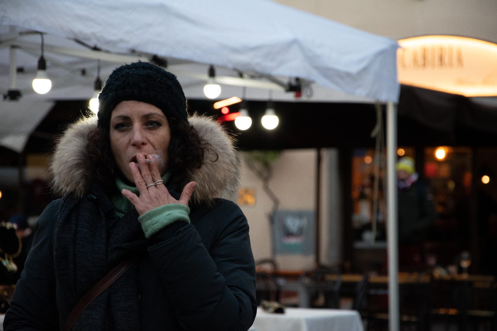 Street — a woman outside a market at night
